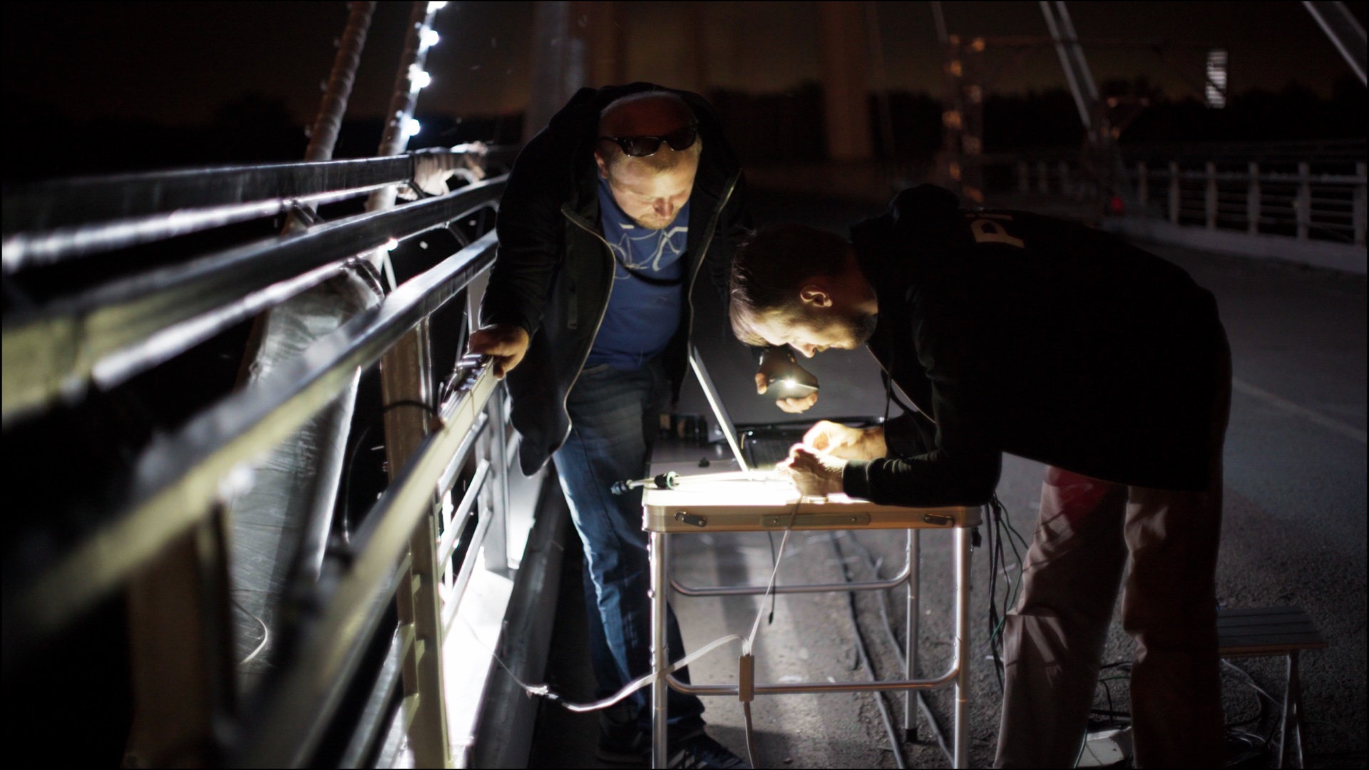 Technicians working on an illuminated bridge