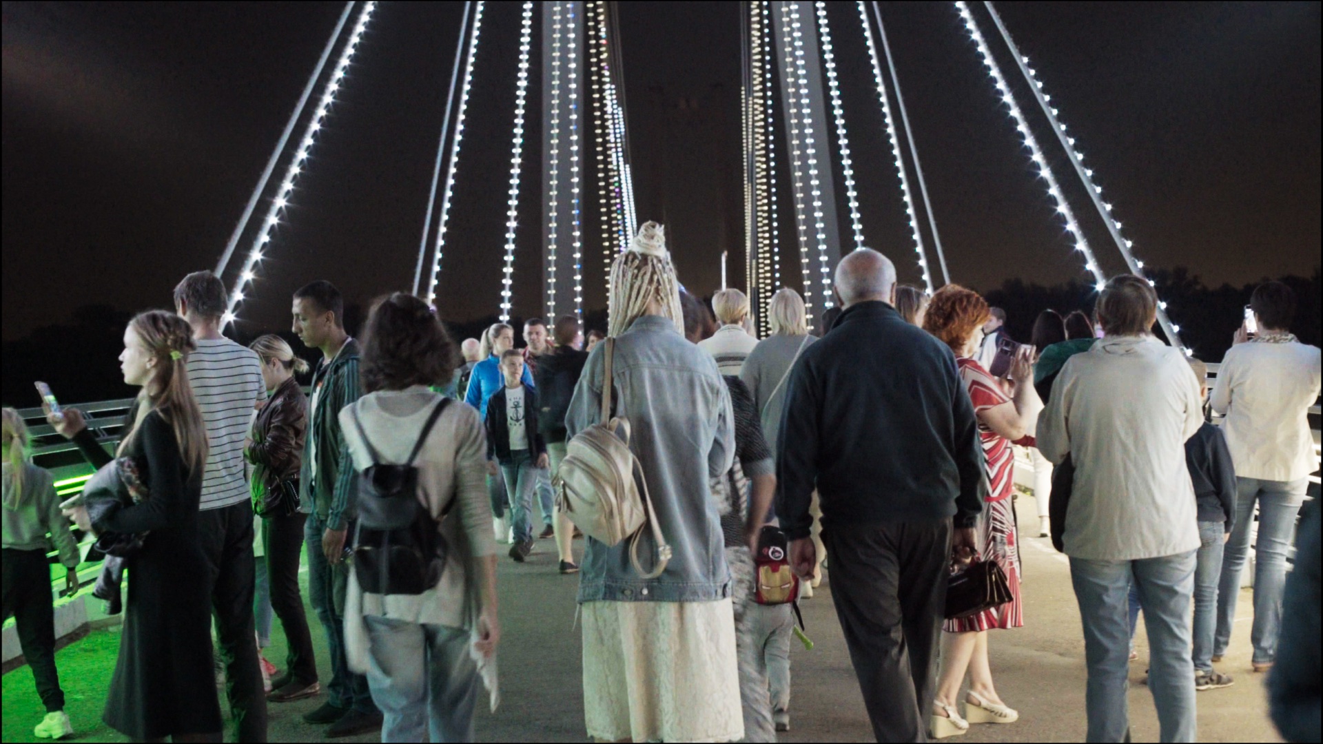 People visiting an illuminated bridge at night