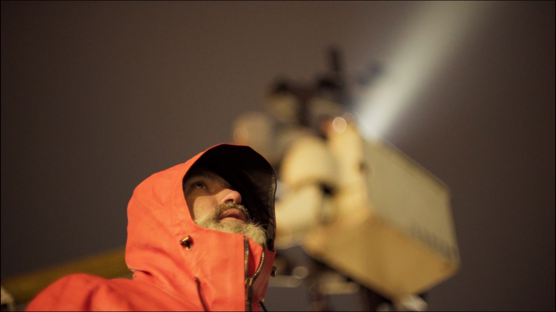 A worker beneath a city light installation
